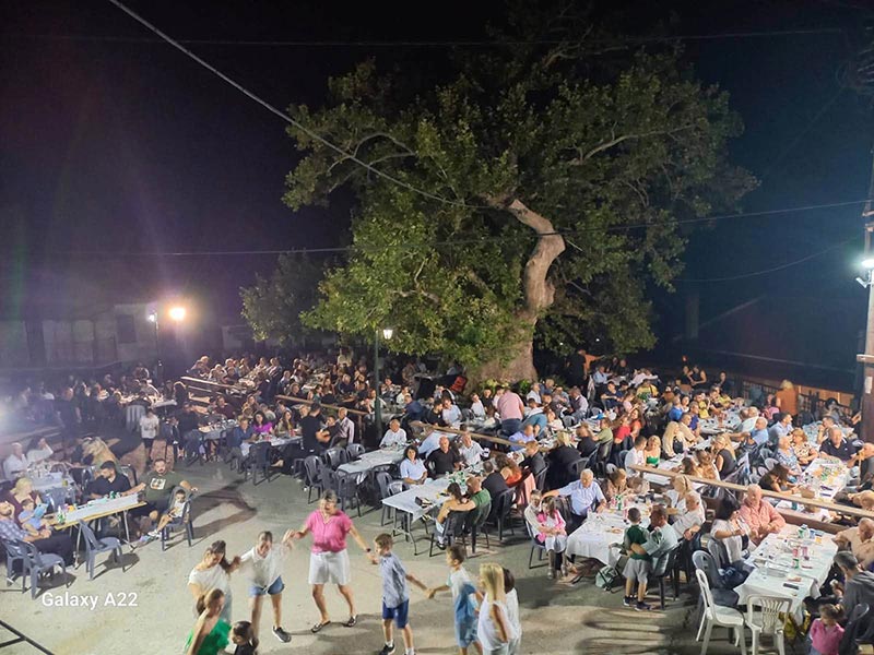 Θέα προς την πλατεία από το Ιατρείο. Η πλατεία είναι γεμάτη κόσμο και στον δρόμο χορεύουν.
